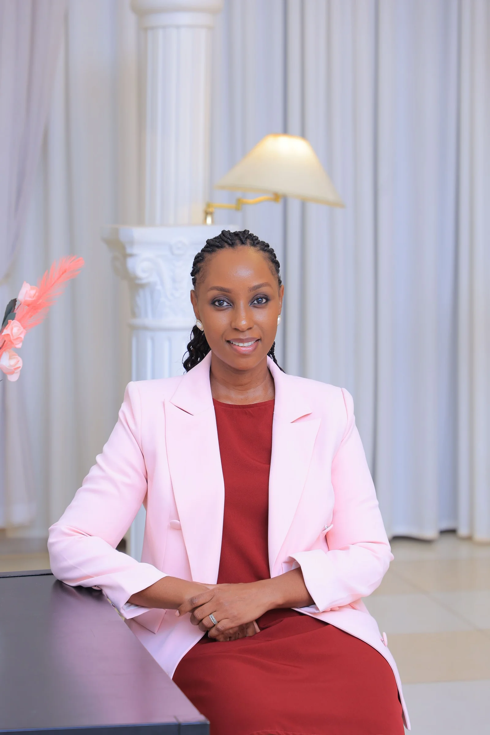 Lois Asiimwe post-procedure looking elegant and confident in a tailored pink blazer
